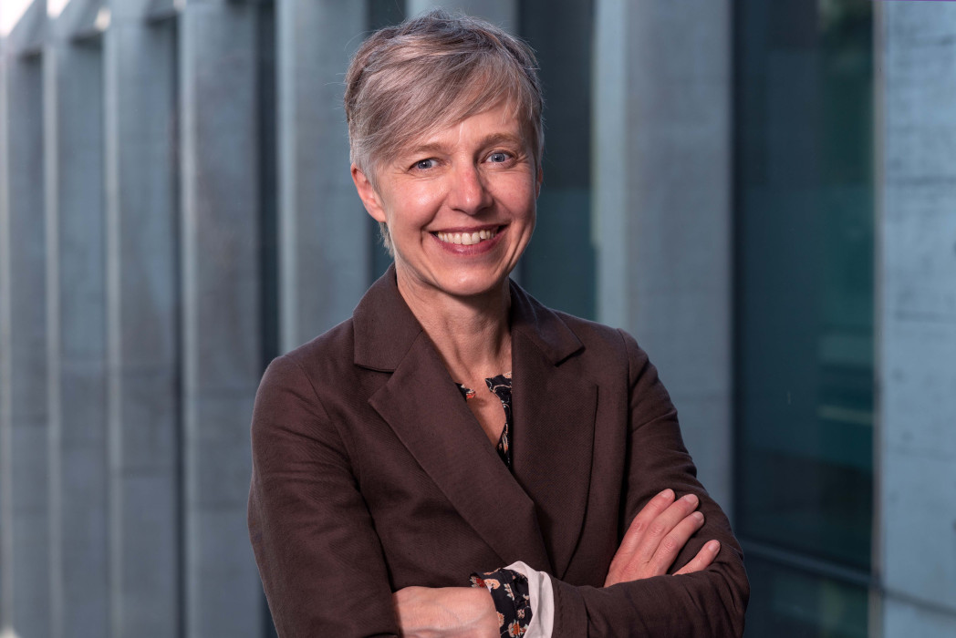 Porträtfoto einer Frau mit kurzen blonden Haaren und braunem Blazer