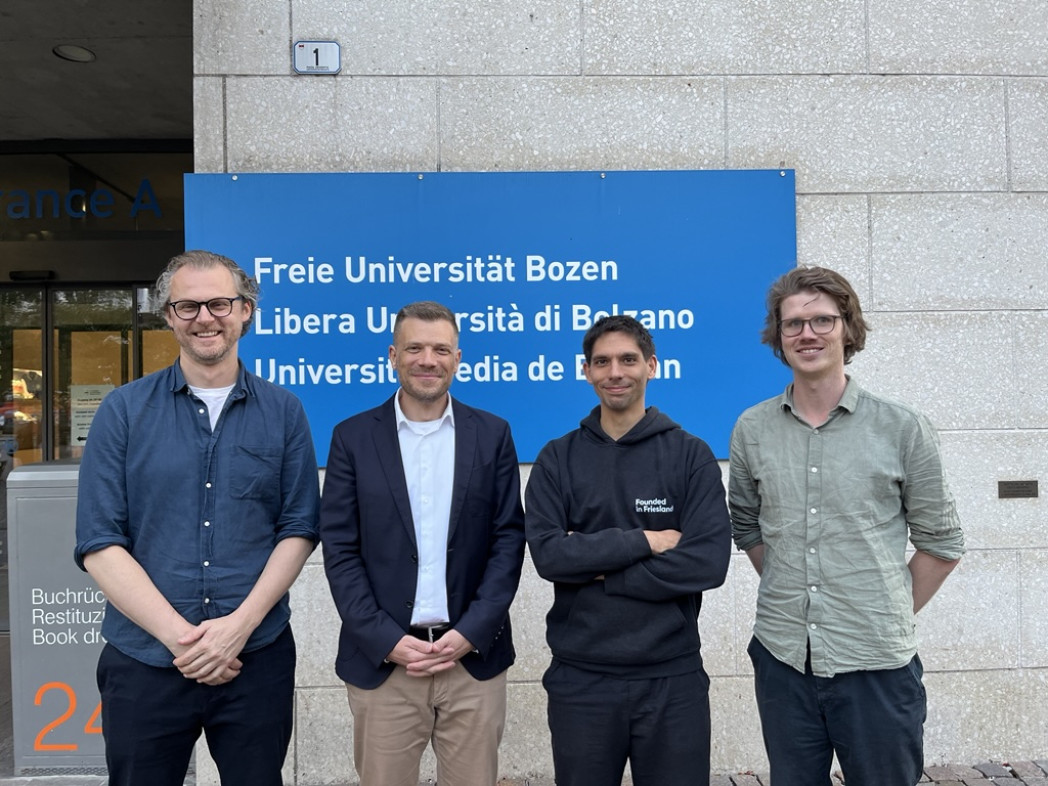 Visiting researchers and Centre's Director posing for a picture in front of the University