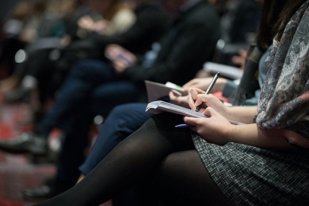 Journalists that write on a book during a press conference