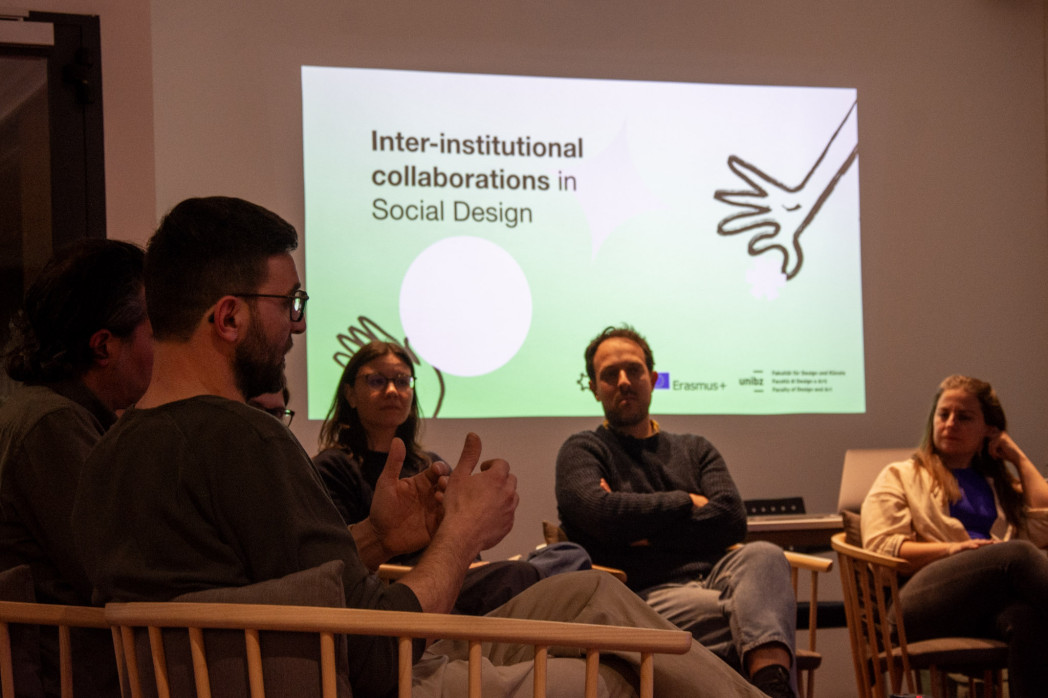 Persone parlano in un semi cerchio su un palco. 