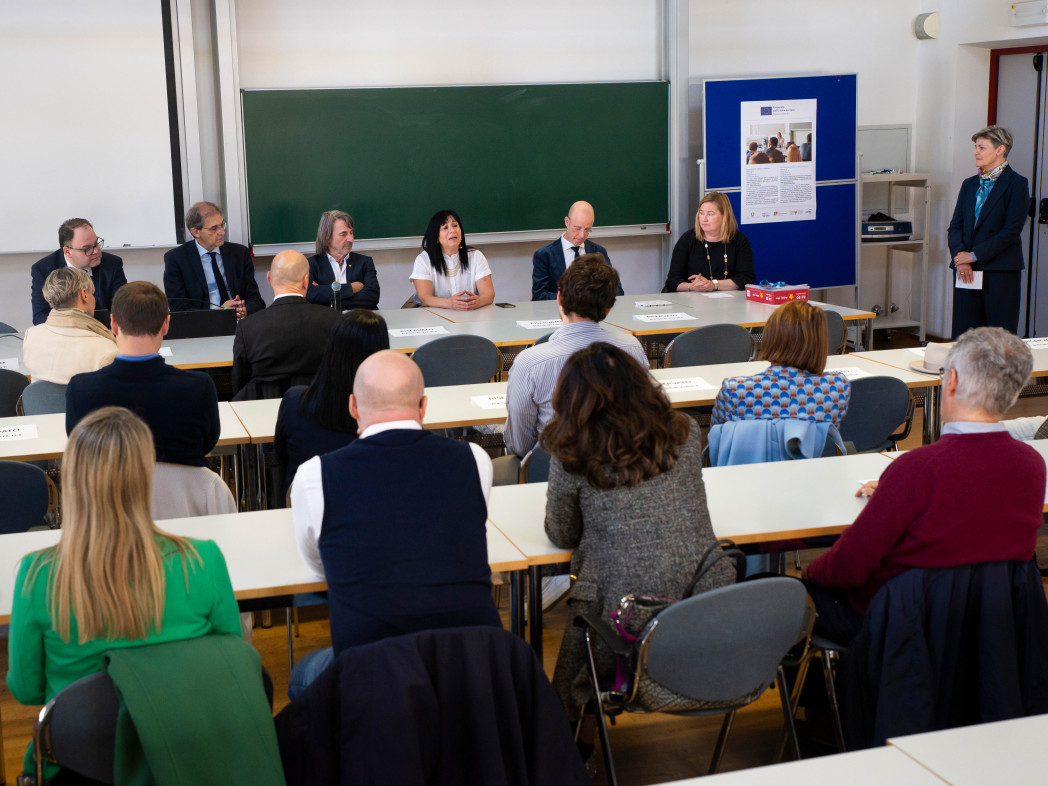 Persone sedute in aula. Una persona parla.