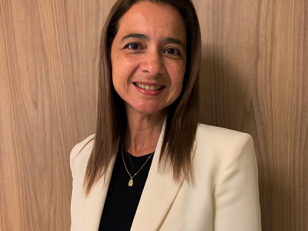 Frau in weißem Blazer vor Holzwand