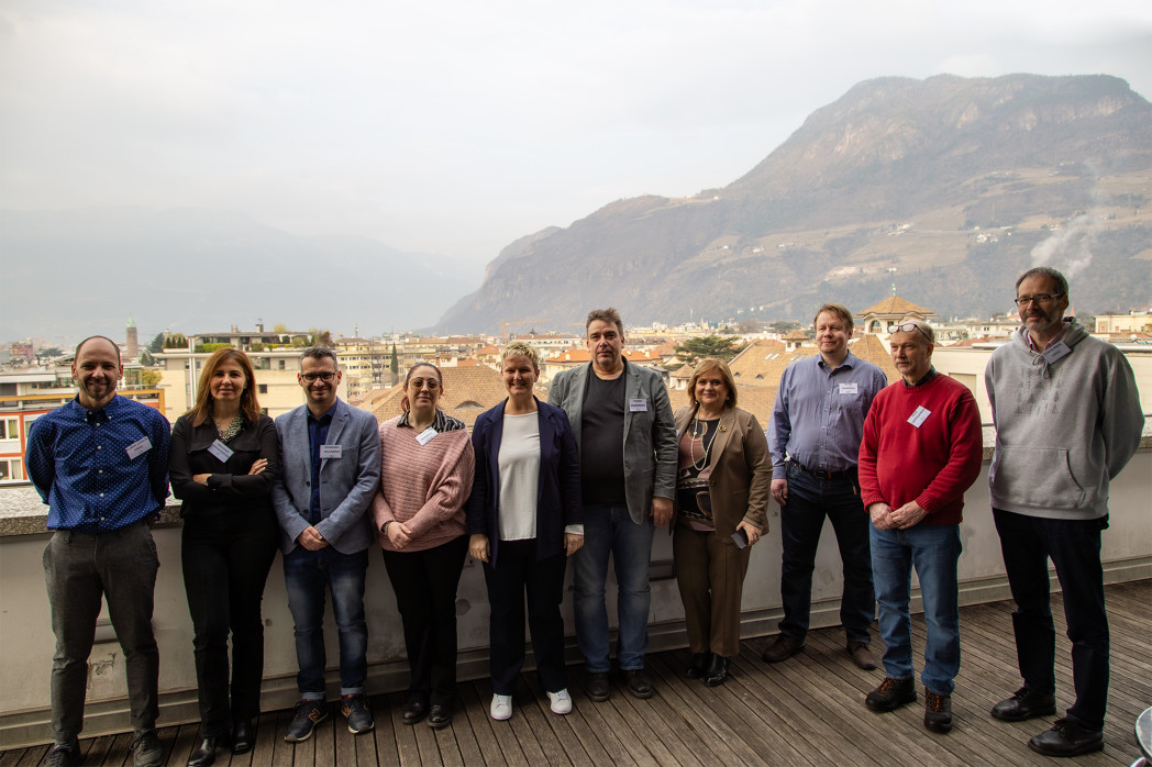 Zehn Personen stehen auf einer Terrrasse.