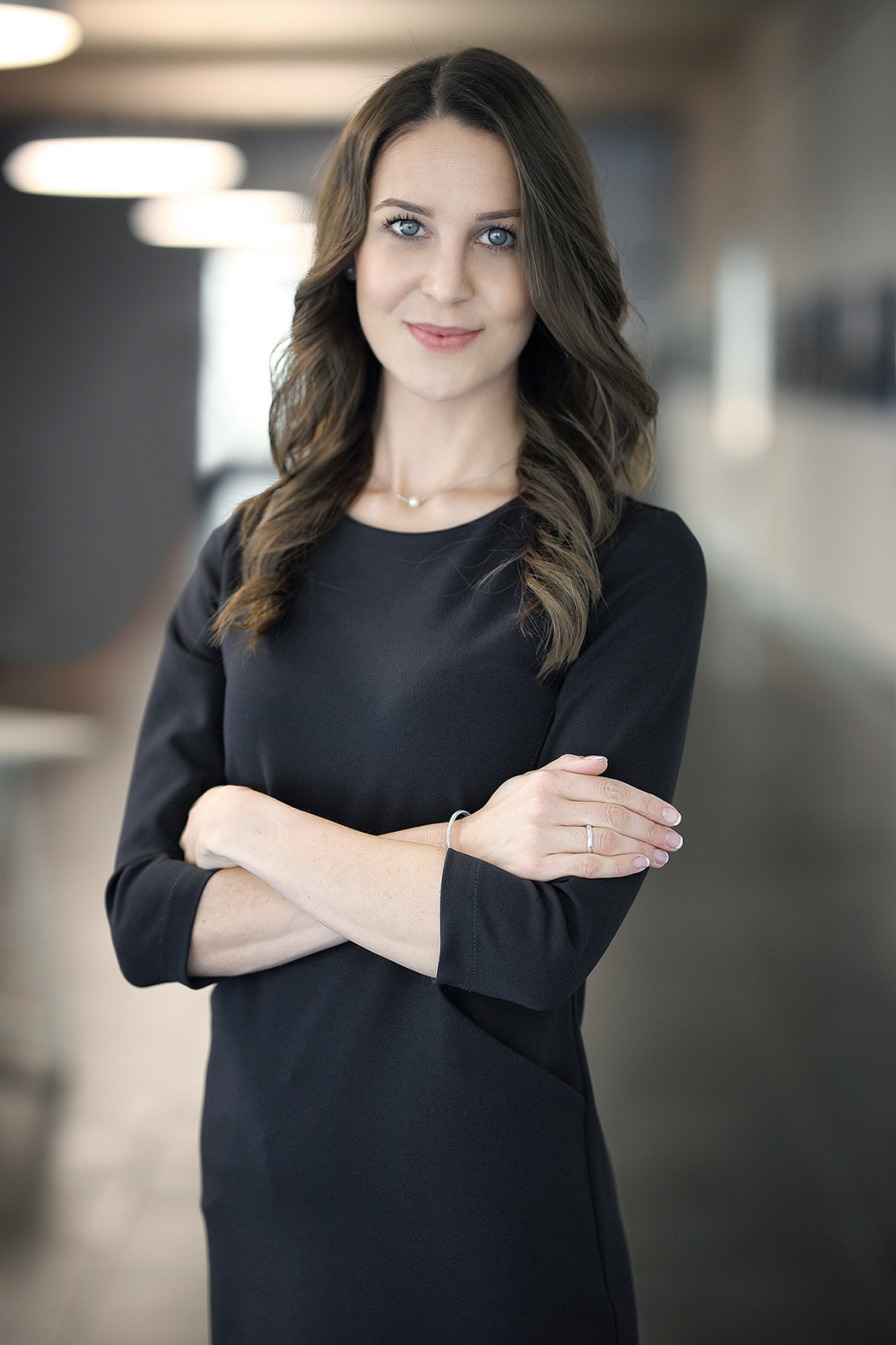 Donna sorridente con le braccia incrociate.