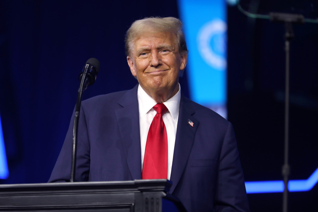 Uomo che sogghigna dietro a un podio