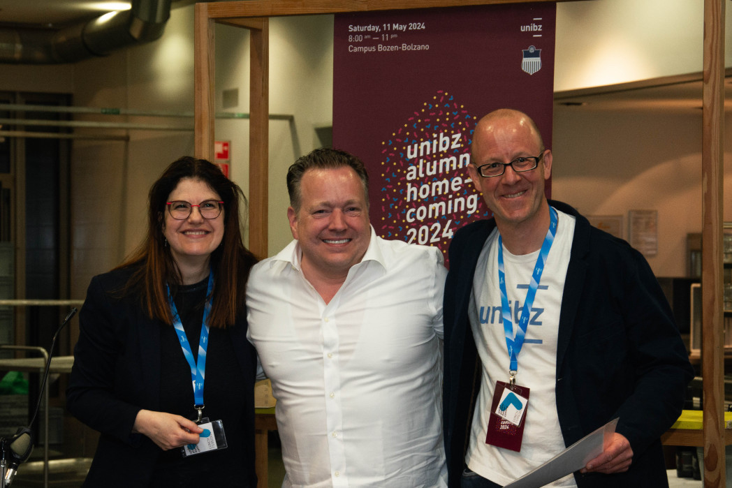 Woman and two men laugh at the camera.