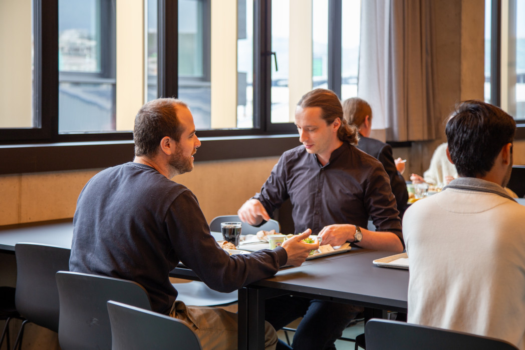 Le persone mangiano sedute a un tavolo.