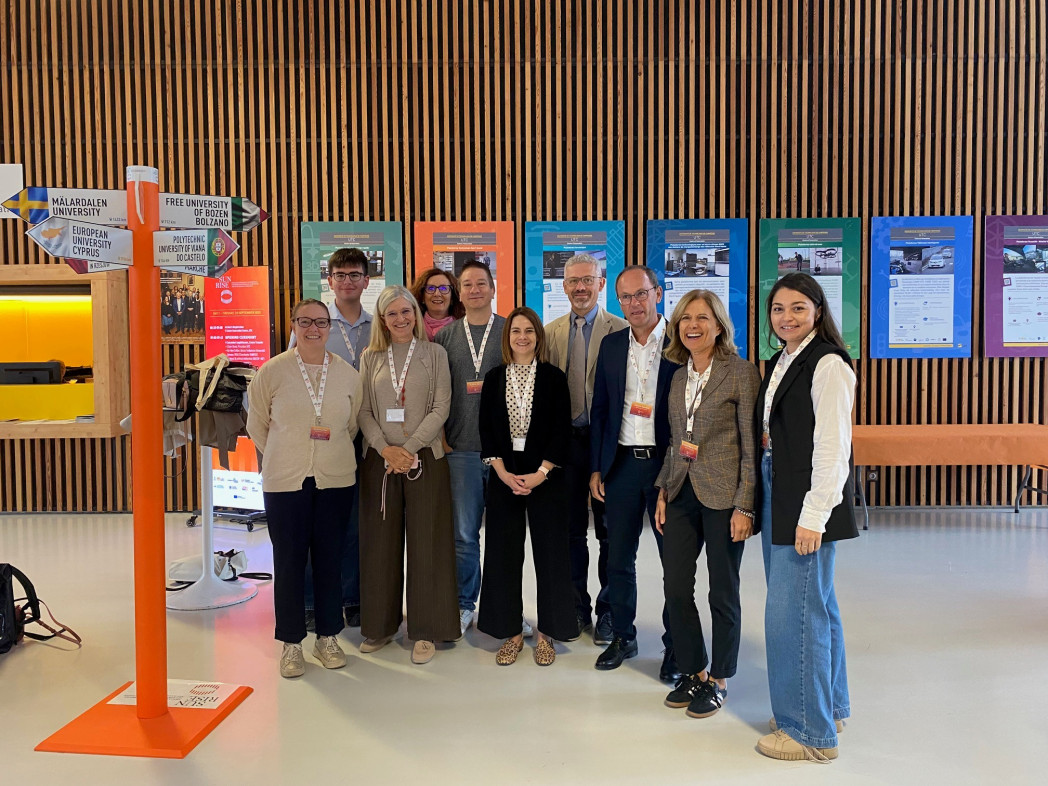 even people standing together in front of an information display wall with wooden paneling and colorful poster boards at a professional event.