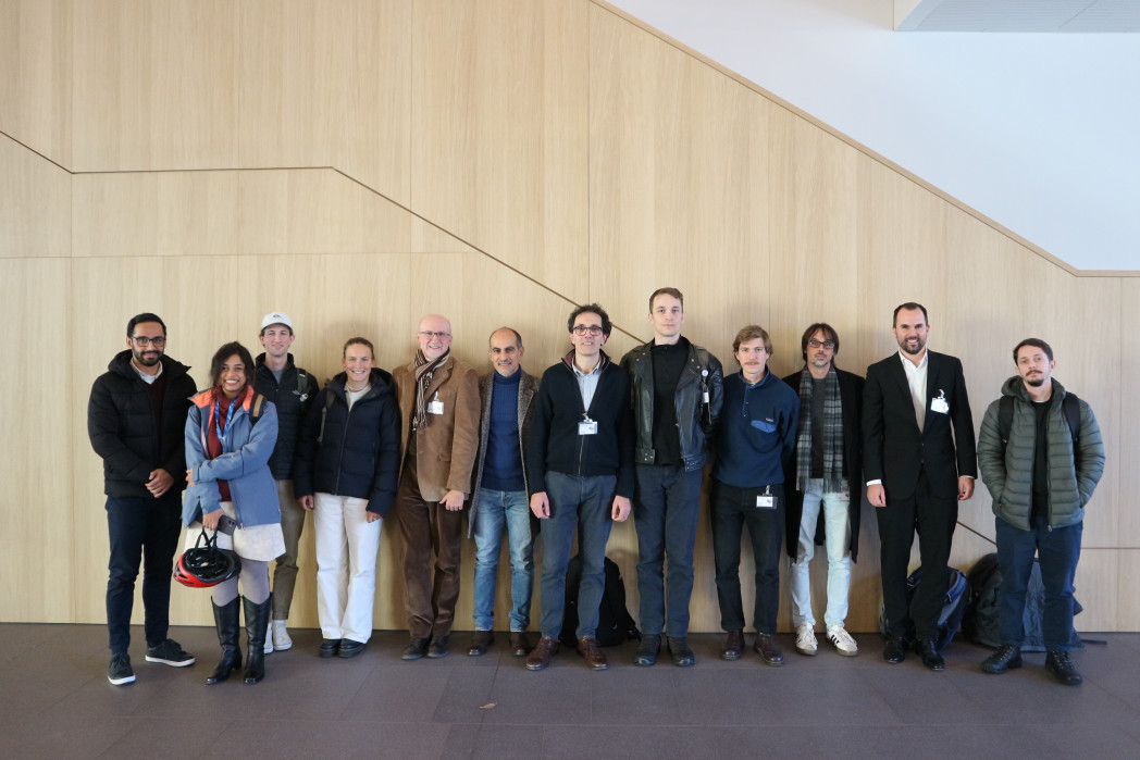 Gruppe von Menschen vor Holzwand