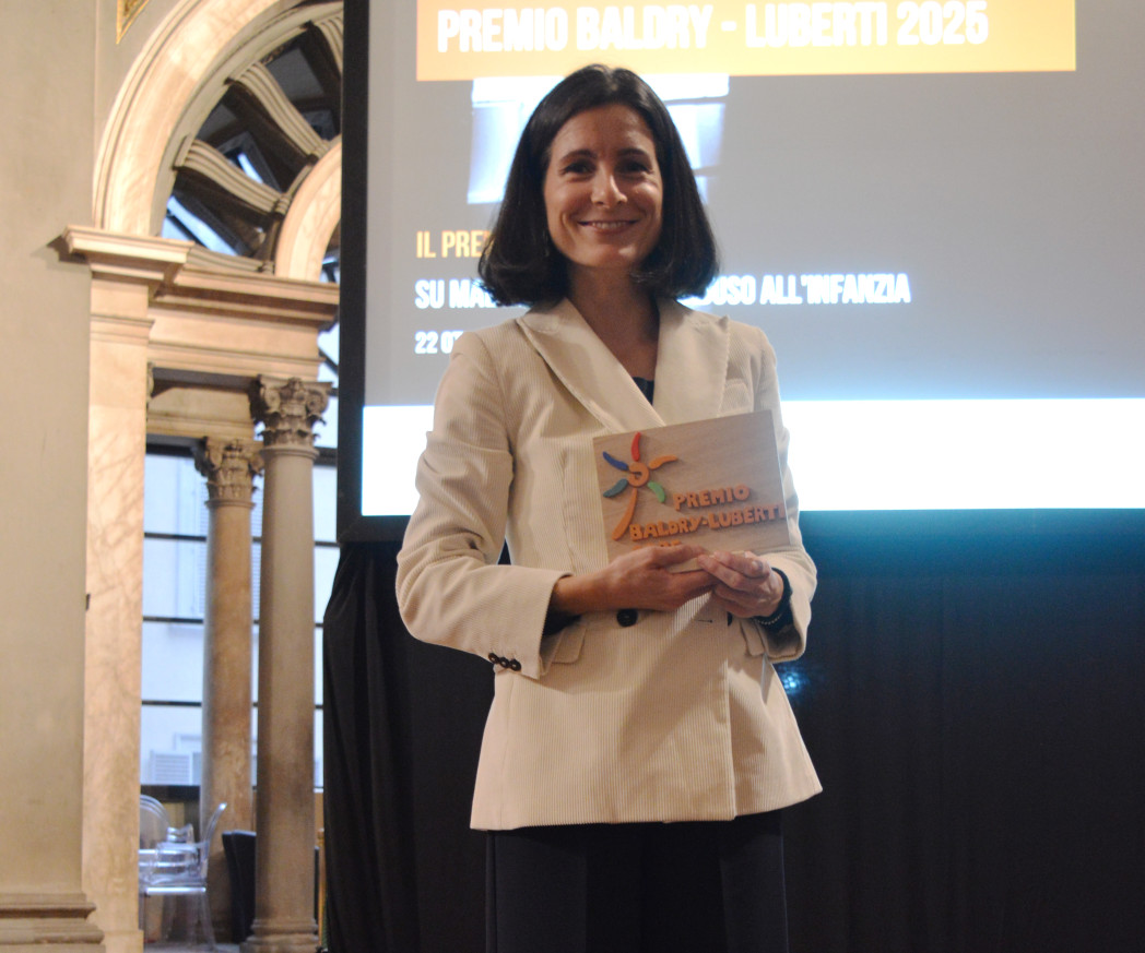 Donna in blazer bianco davanti a uno schermo di proiezione