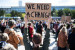 Bild von Demonstration auf einem Platz, Menschen von hinten, Frau hält Schild mit "We need a change" hoch