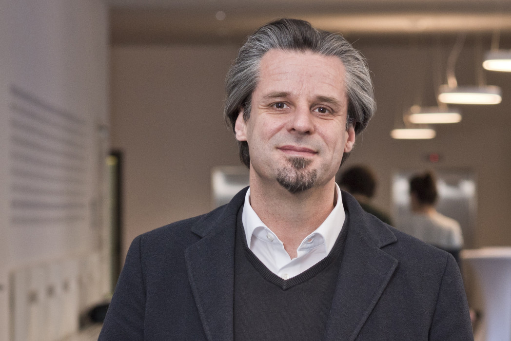 Eine Person steht im einem Korridor der Universität.