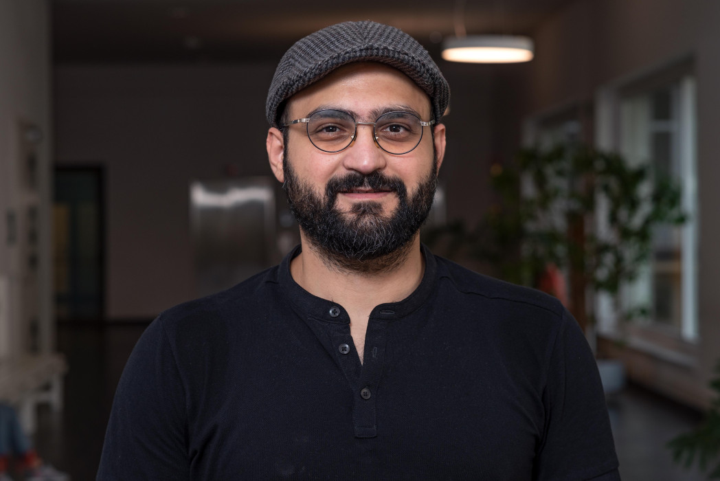 Mann mit Brille und Kappe auf Gang der unibz