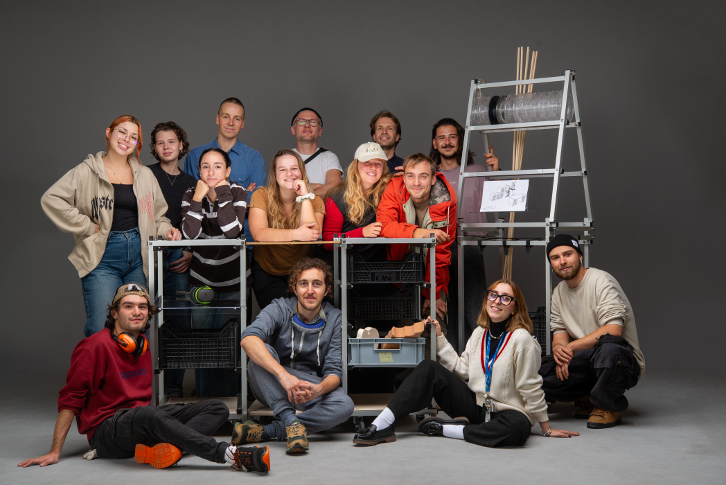 Gruppo di persone in posa con attrezzature tecniche in studio.