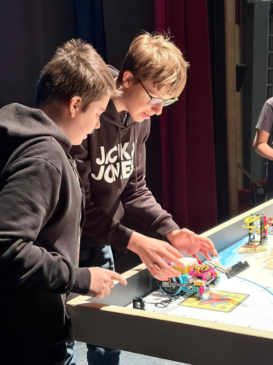 Ragazzi davanti ad un tavalo con dei robot di lego.