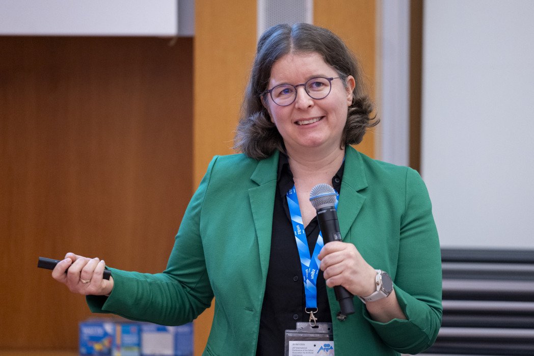 Frau in grünem Blazer mit Mikrofon in der Hand