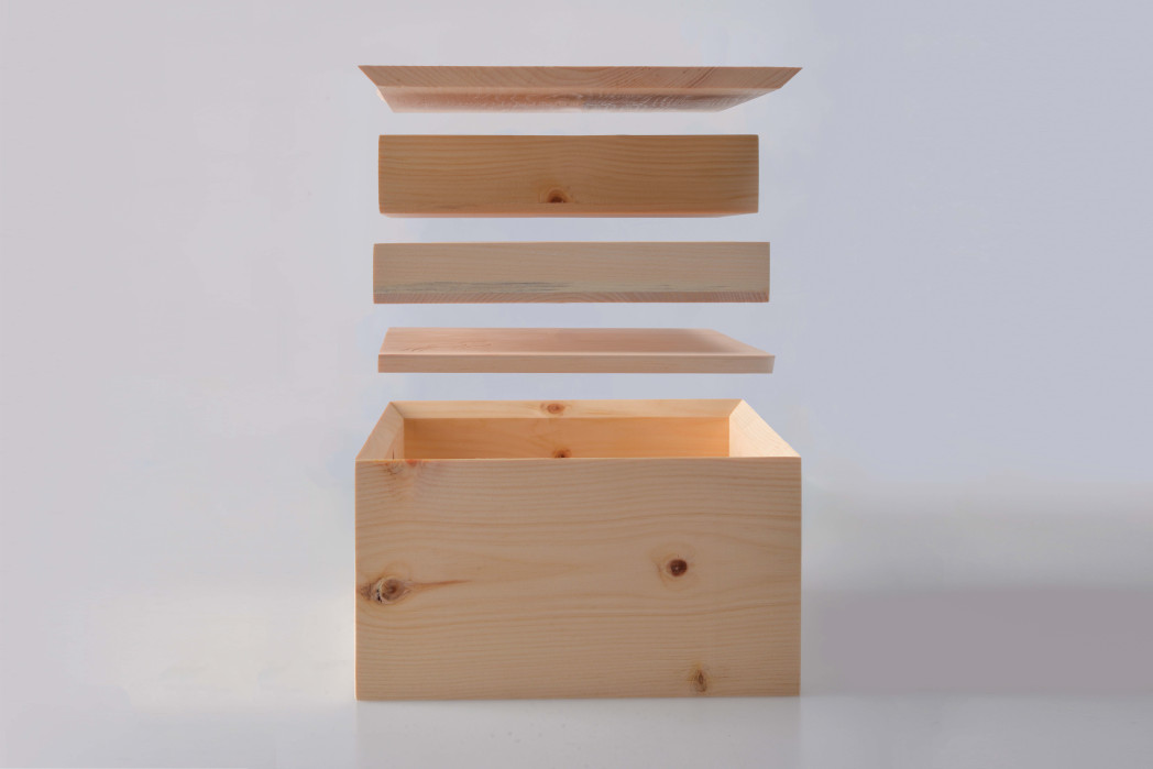 Un piccolo scrigno in legno di cirmolo intagliato con simboli beneauguranti.