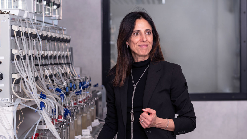 La professoressa Raffaella di Cagno in un laboratorio con molte provette e fiale piene di liquido.