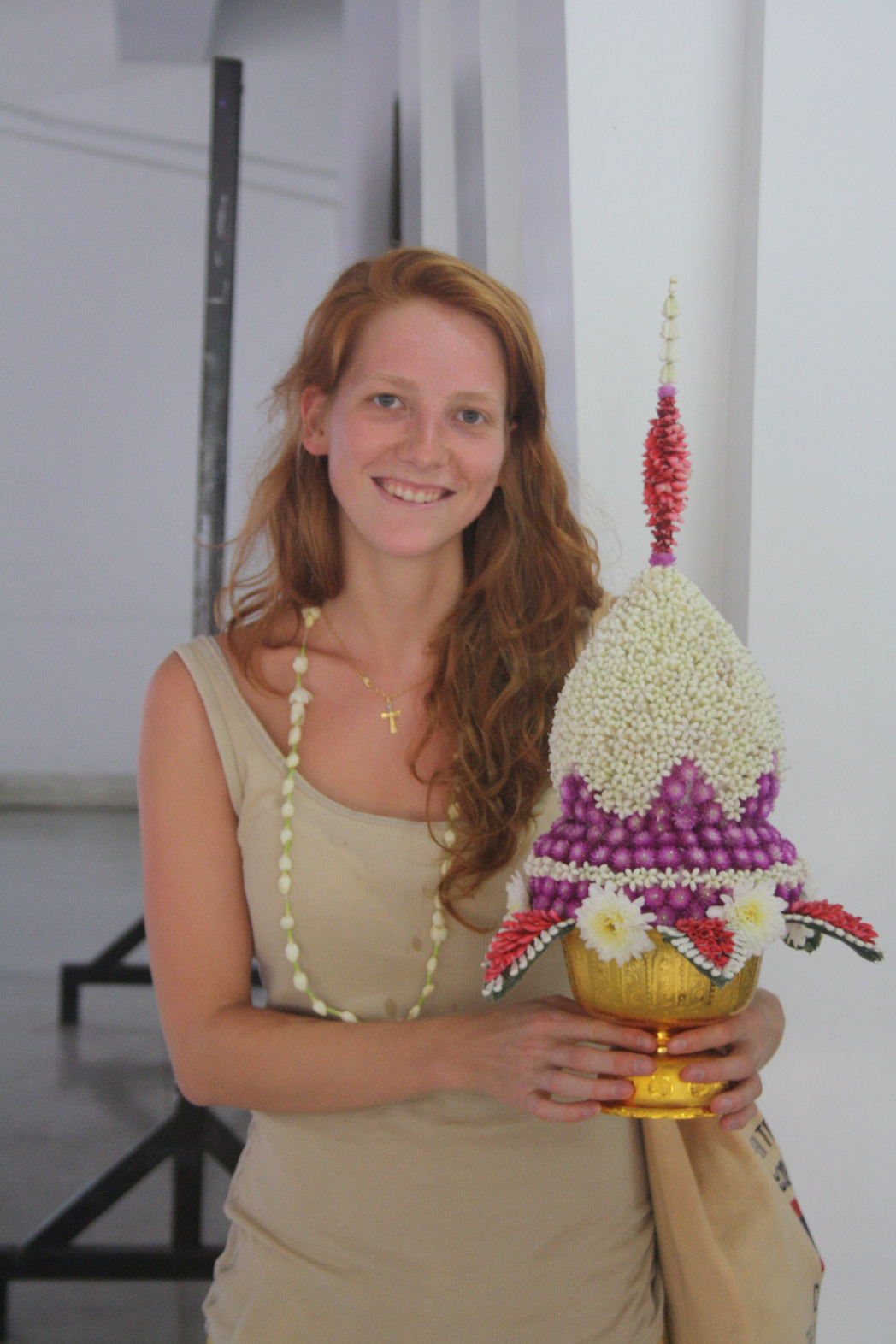 Lächelnde Frau mit asiatischer Blumenschale in der Hand