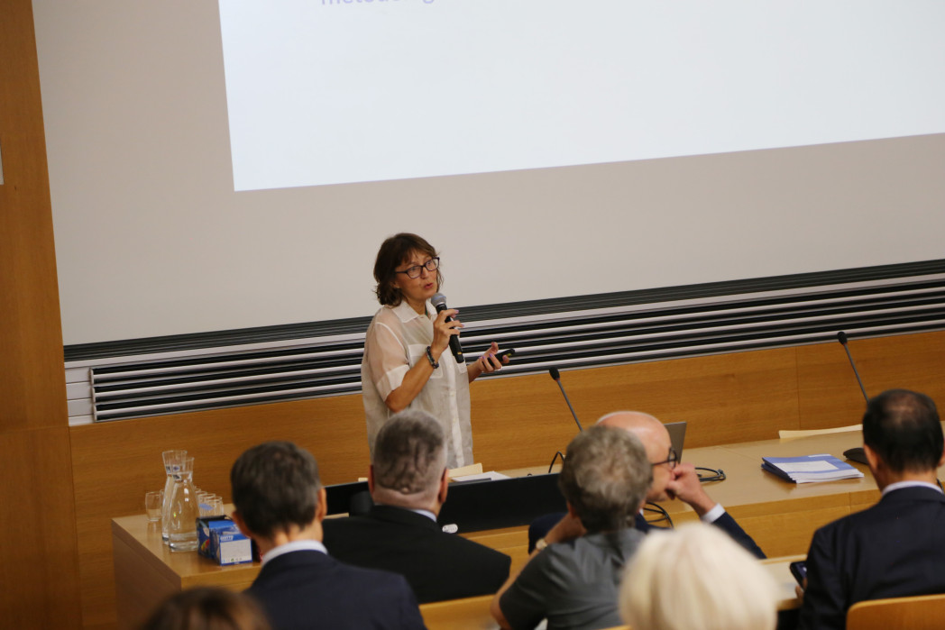 Una donna parla davanti a un pubblico in un'aula.