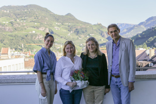 (v.l.) Silvia Dal Sasso (Studierendenvertreterin im Beirat), Marjaana Gunkel, Alessandra Papa (Beiratsmitglied) und Rektor Prof. Paolo Lugli. Porträt auf Dachterrasse, mit Bergen im Hintergrund.