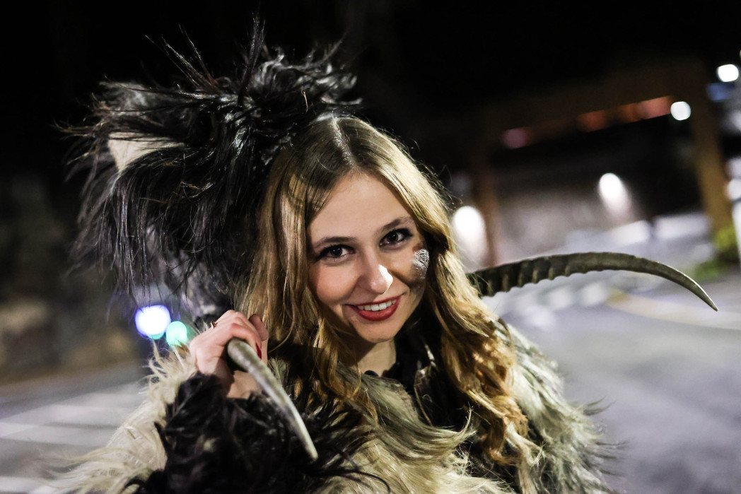 ein Mann und eine Frau in Krampuskleidung bei einem Umzug, aber ohne Maske - die halten sie in der Hand