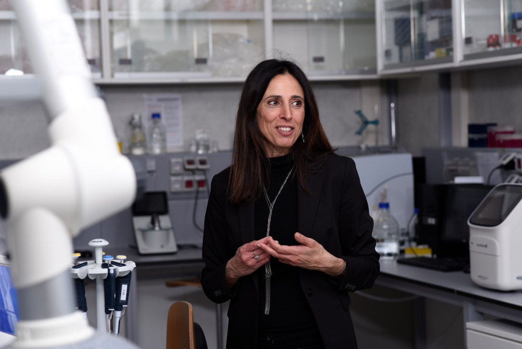 Frau in Labor vor Vorrichtung mit Flaschen und Kabeln. 