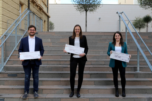 Die drei Preisträger*innen Patuzzi, Cottini und Rovella mit je einem Scheck von 5000 Euro in der Hand auf Stufen vor der unibz. iftung Südtiroler Sparkasse an der unibz vergeben