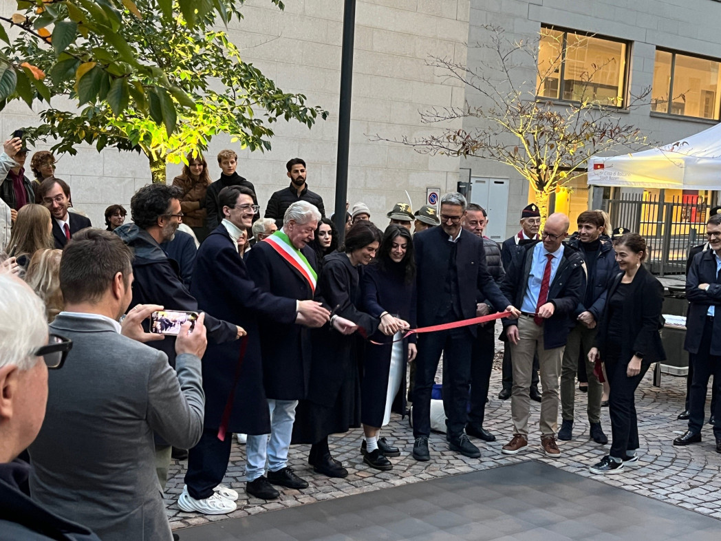 Menschen stehen rund um den begehbaren Bildschirm. Das Band zur Einweihung des Mahnmals wird durchschnitten.