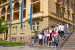 Studierende aus Ukraine stehen mit Präsidentin Tappeiner und Direktor Mathà auf Stufen , im Hintergrund Gebäude G uind blaue Unifahnen
