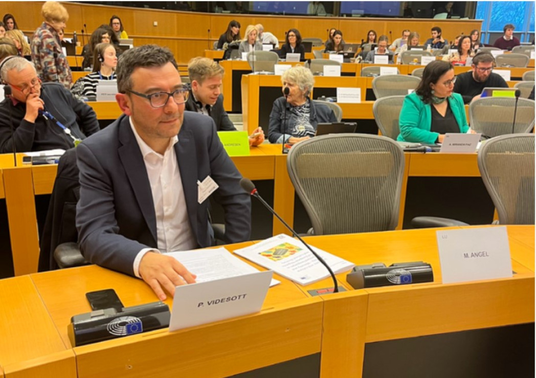 Eine Person sitzt an einem Tisch im EU Parlament.