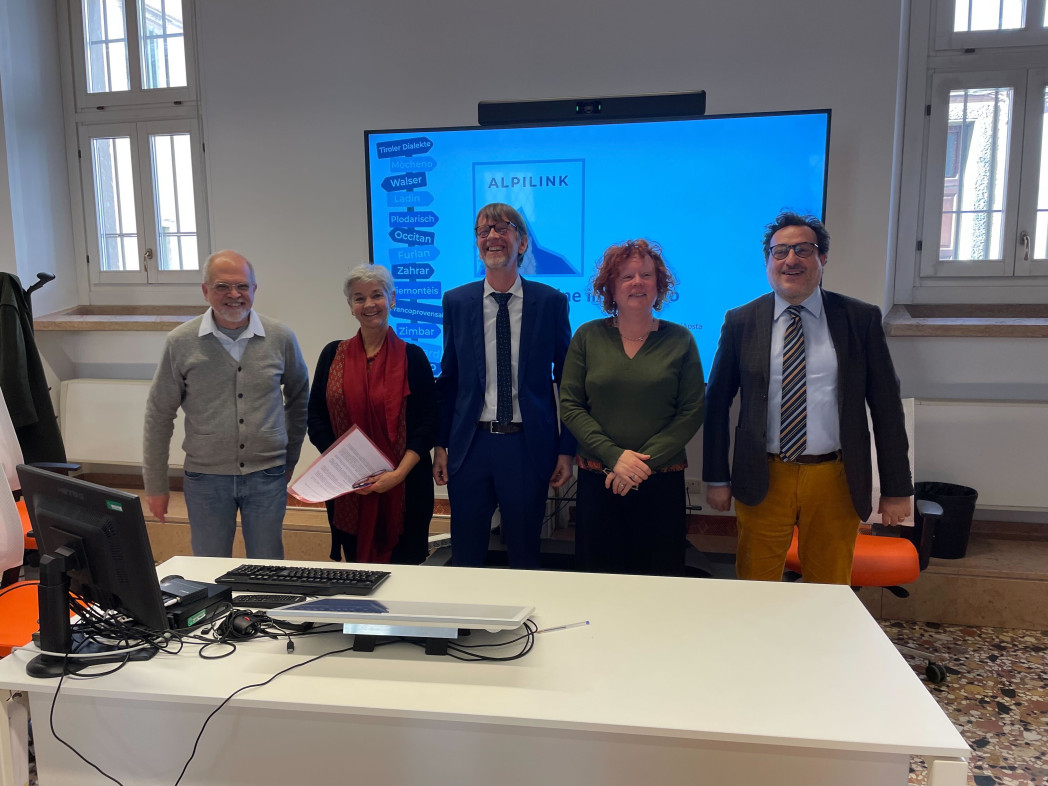 Fünf Personen stehen in einem Hörsaal.