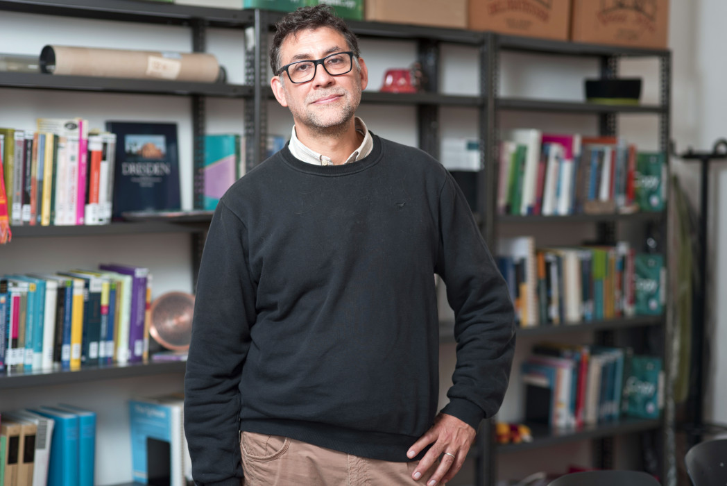 Il prof. Enrico Franconi di fronte a uno scaffale di libri.