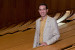 Porträtfoto von Prof. Antonio Liotta in beigem Jackett und gelbem Hemd in einem Hörsaal 
